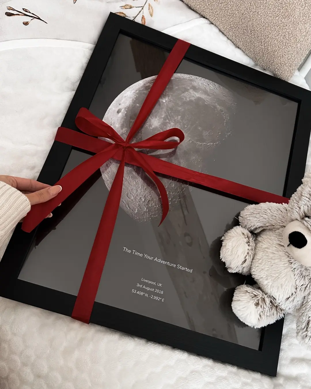Framed moon map print gift wrapped with red ribbon